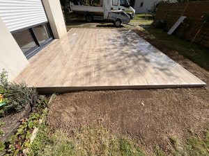 Nouvelle terrasse en bois imitation parquet près d'une maison